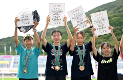 Ｕ１６女子１０００メートルで２位に入賞し、表彰台で賞状を掲げポーズをとる人見仁菜（左から２人目、足寄中２年）