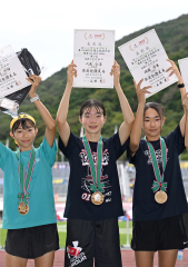 Ｕ１６女子１０００メートルで準優勝し、表彰台で賞状を掲げる人見仁菜（中央、足寄中２年）