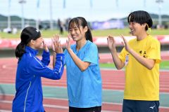 Ｕ１８女子１００メートルＡ決勝で準優勝をした山崎心愛（旭川志峯２年－音更共栄中出、中央）。表彰式で入賞者とハイタッチを交わして健闘をたたえあう