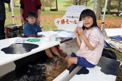 ふく井ホテルのモール温泉にほっこり―。雨も降り冷え込む会場で足湯を楽しむ子どもたち