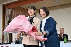 「リラの風」の佐々木直美会長（右）から花束を受け取る石川香織氏（２７日午後８時４５分ごろ、塩原真撮影）