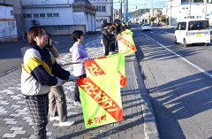 旗を持って安全運転を呼び掛ける参加者ら