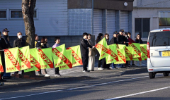 旗を持って安全運転を呼び掛ける参加者ら