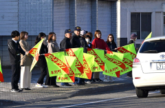 旗を持って安全運転を呼び掛ける参加者ら