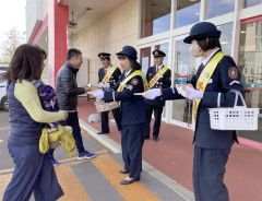 買い物客に啓発資料を手渡す足寄消防団員ら（足寄）