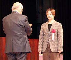 岡田会長（左）から記念の盾を受ける鈴木代表（右）