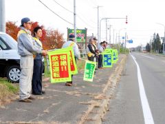 国道沿いで旗を掲げ、安全運転を呼び掛ける会員たち