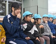 焼き芋を食べながら交流する高校生と園児