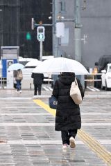 雨の中、足早に歩く通行人（２２日午前９時２０分ごろ、ＪＲ帯広駅前で。須貝拓也撮影）