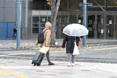 雨の中、足早に歩く通行人（２２日午前９時１５分ごろ、ＪＲ帯広駅前で。須貝拓也撮影）