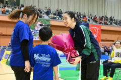 開会式で、芽室町バドミントン少年団から花束を受け取る北都銀行の永原和可那選手（中央、青森山田高－芽室中出）＝金野和彦撮影