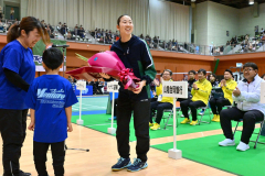 開会式で、芽室町バドミントン少年団から花束を受け取る北都銀行の永原和可那選手（中央、青森山田高－芽室中出）＝金野和彦撮影