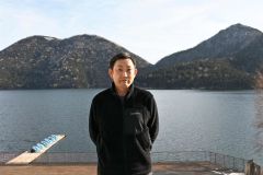 然別湖を前に、湖面に山が写ることで唇に見える天望山を説明する石川さん