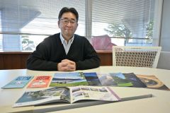 手がけた観光ガイドなどを前に、課題と今後について説明する大西さん