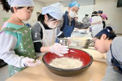 そば打ちを体験する児童ら