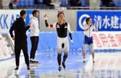 女子５００メートルで３７秒８６のタイムで優勝を飾り、ヨハン・デビットコーチとタッチを交わす高木美帆（中央）＝金野和彦撮影