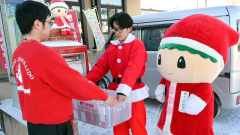 サンタカードを郵便局員に手渡す町職員と「さーたちゃん」（１６日午前１０時ごろ）