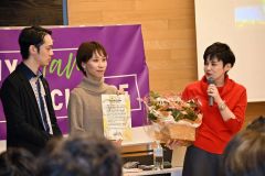 選択的夫婦別姓を求める札幌訴訟の原告佐藤万奈さん（中央）と西清孝さんから花束を受け取り、感謝の気持ちを口にする上田さん（右）