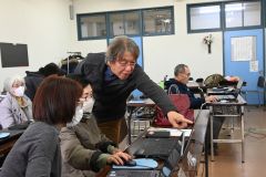 画面を指しながら会員に説明する綱島さん