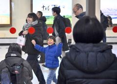 荷物受け取りスペースからガラス越しに手を振る子ども（２８日午前９時４０分ごろ、塩原真撮影）