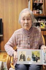 母のカツさんの写真（左端）を掲げる松本泰子さん（助川かおる通信員撮影）