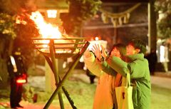 参道を照らす炎が参拝者の凍えた手を温めた（１日、帯廣神社で。金野和彦撮影）