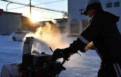 元旦は雪かきからスタート－。初日の出に照らされ、除雪に追われる市民（１日、帯広市内で）