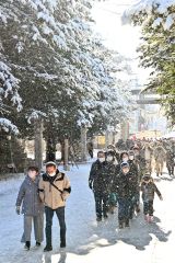 ３１日に降り積もった雪が木々の枝から降り注ぎ、きらきらした粉雪が参拝客の目を楽しませた（１日、帯廣神社で。金野和彦撮影）