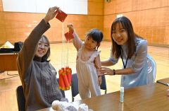 完成した旧正月の飾り付けを持つ親子とミーさん（右）