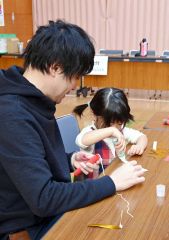 協力して旧正月の飾り付けを作る親子