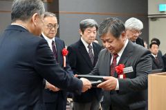 記念の盾を受け取る松岡義文氏