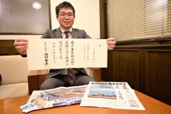 ２５日に届いた「宮内庁長官名による証状」を手に笑顔を見せる菊池さん