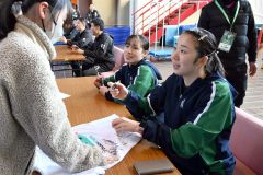 試合後、ファンや子どもたちにサインを書く北都銀行の永原和可那選手(右手前)=金野和彦撮影