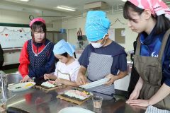 恵方巻き作りに挑戦する子どもたちとサポートする生徒たち