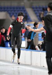 【男子５００メートル】滑走後に仲間選手とハイタッチする宮本哲朗（帯一）