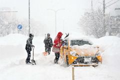 スタックした車を助けようと集まる市民ら（４日午前７時５５分ごろ、帯広市東４南１５）