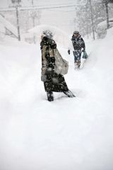 埋もれながら歩く市民（４日午前７時４０分ごろ、帯広市東６南１５）