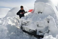 雪に埋まった車を掘り出す空港駐車上利用者（５日午前１０時半ごろ））