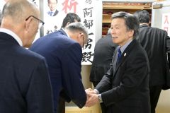 支援者と握手を交わす阿部氏（右、９日午後８時５０分ごろ）