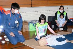 救急救命訓練でダミー人形を使って心肺そ生に挑戦する子ども（８日、下音更小体育館）
