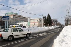 路肩の雪が大きくせり出した玄武通にある協立病院前のバス停付近（１４日）