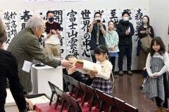 勝山哲峯展覧会会長から賞状と盾を受け取る児童