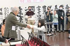 勝山哲峯展覧会会長から賞状と盾を受け取る児童