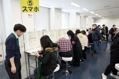 職員らのサポートを受けながらスマートフォンで確定申告を行う納税者（１７日午前９時半ごろ、須貝拓也撮影）