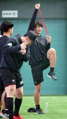 練習試合前に室内でウォーミングアップをするロッテの河村説人（右）＝沖縄・コザしんきんドーム