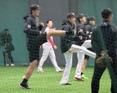 練習試合前に室内でウォーミングアップをするロッテの河村説人（左）＝沖縄・コザしんきんドーム