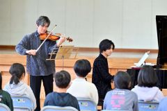 ６年生の前で美しい音色を響かせるバイオリニストの和光憂人さん（左）とピアニストの長尾崇人さん（右）＝金野和彦撮影