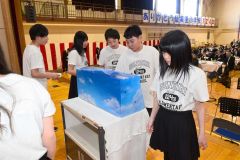 惜別の会で、思い出の品をタイムカプセルに封入する仙美里小の児童
