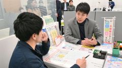 高額を下ろそうとする客に対応する行員（右）