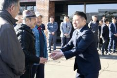 初登庁に駆けつけた支援者と握手を交わす辻町長